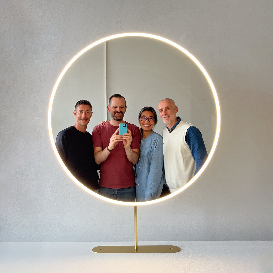 The Alguacil & Perkoff team reflected in an luxury bespoke and illuminating countertop mirror.
