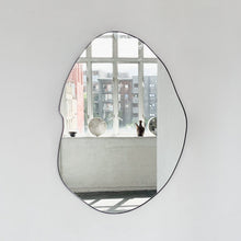 Modern freeform organic shaped mirror with a black powder coated aluminium frame