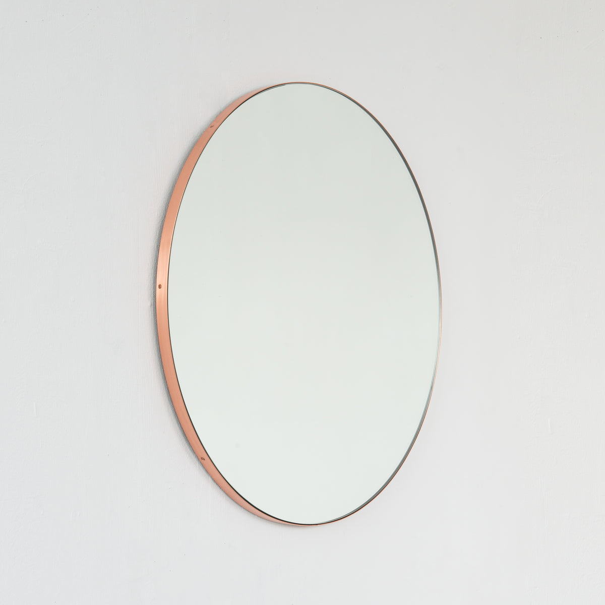 Modern round mirror with a minimalist copper frame