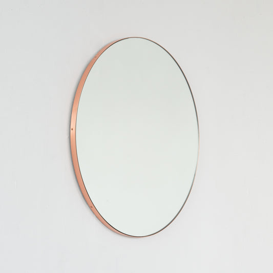 Modern round mirror with a minimalist copper frame