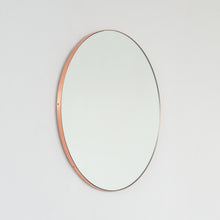 Modern round mirror with a minimalist copper frame