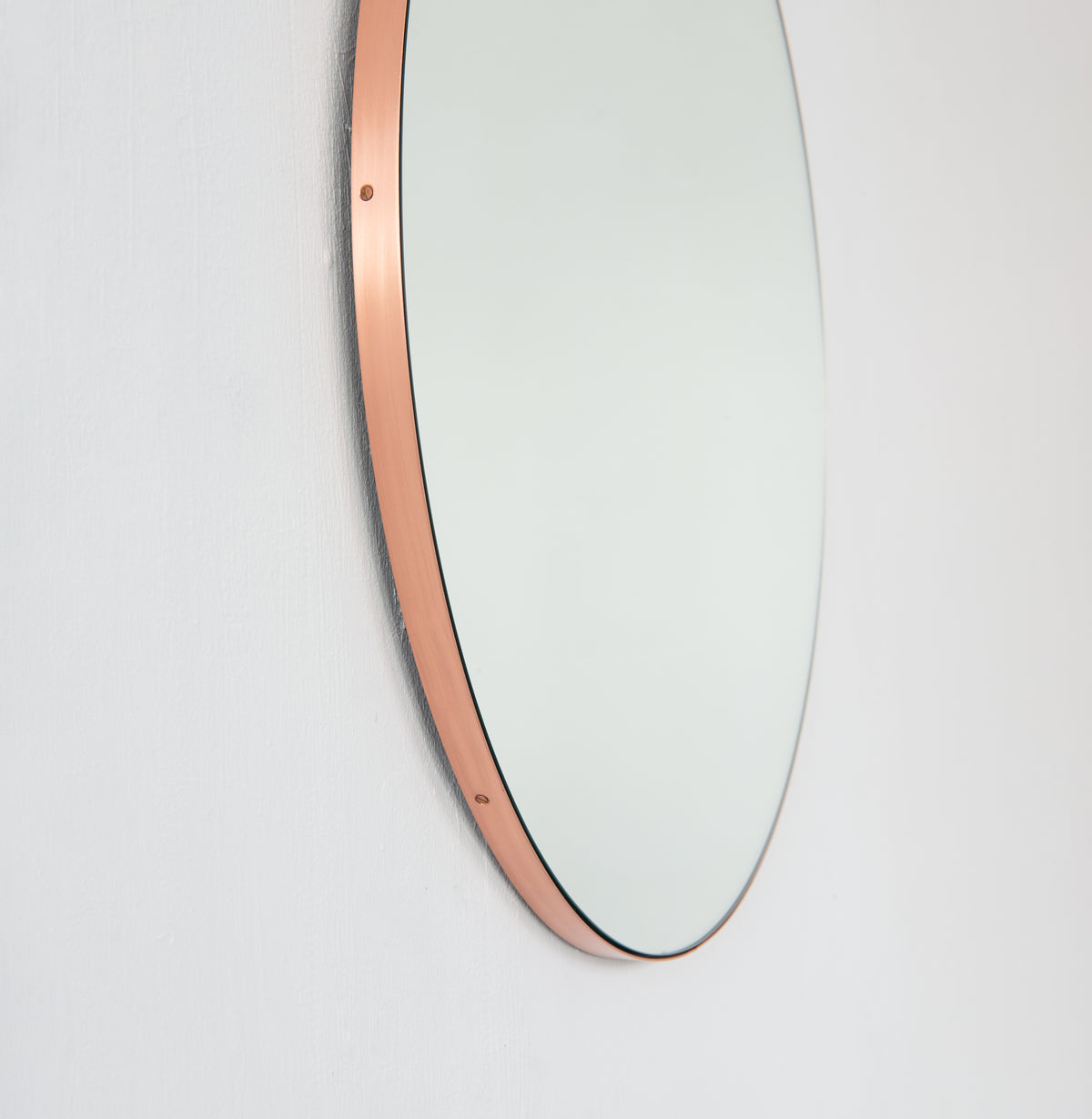 Modern round mirror with a minimalist copper frame
