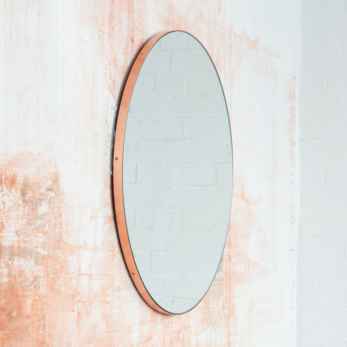Modern round mirror with a minimalist copper frame