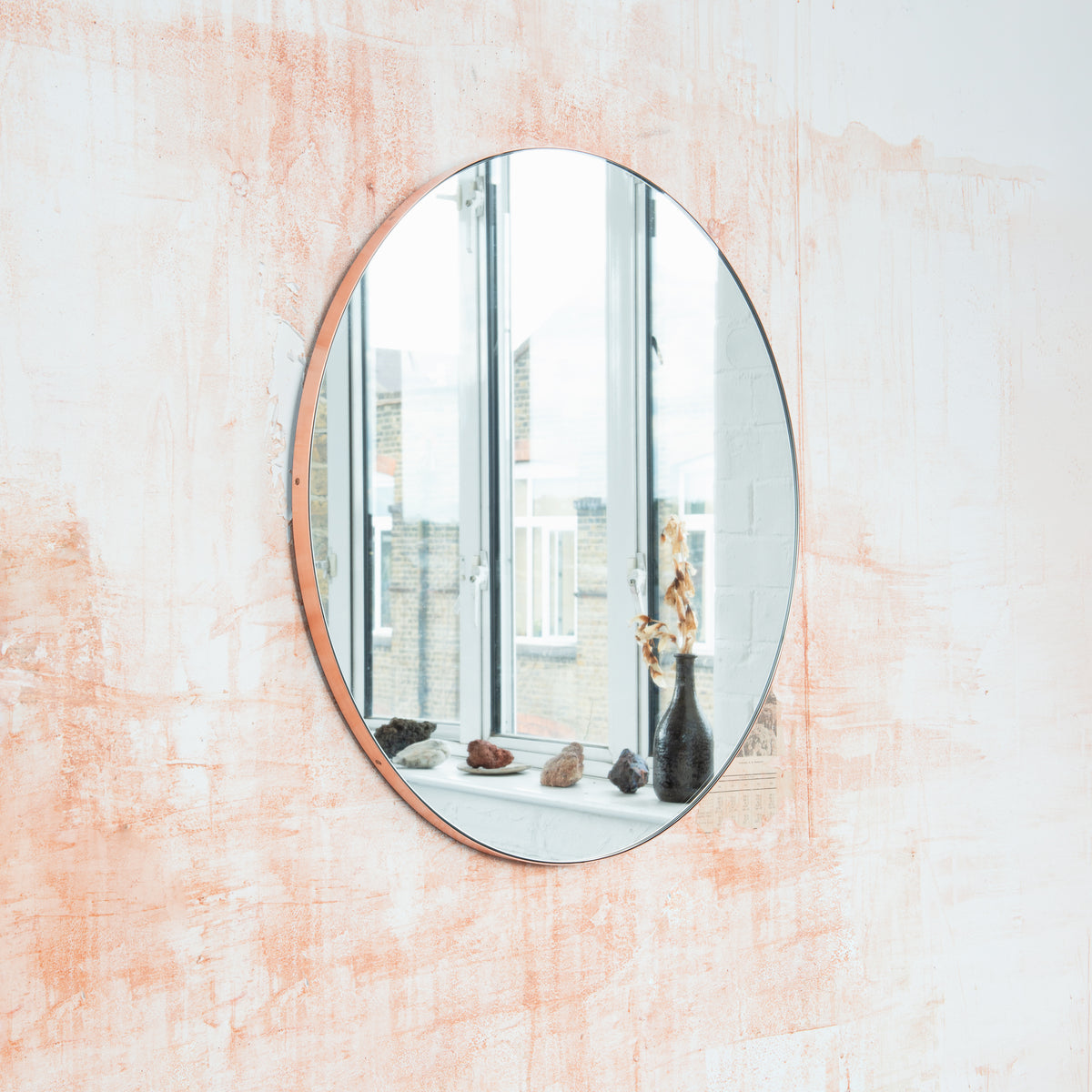 Modern round mirror with a minimalist copper frame