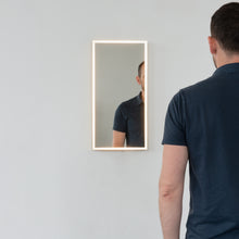 Front illuminated Quadris™ rectangular mirror with square corners and a solid brushed brass frame