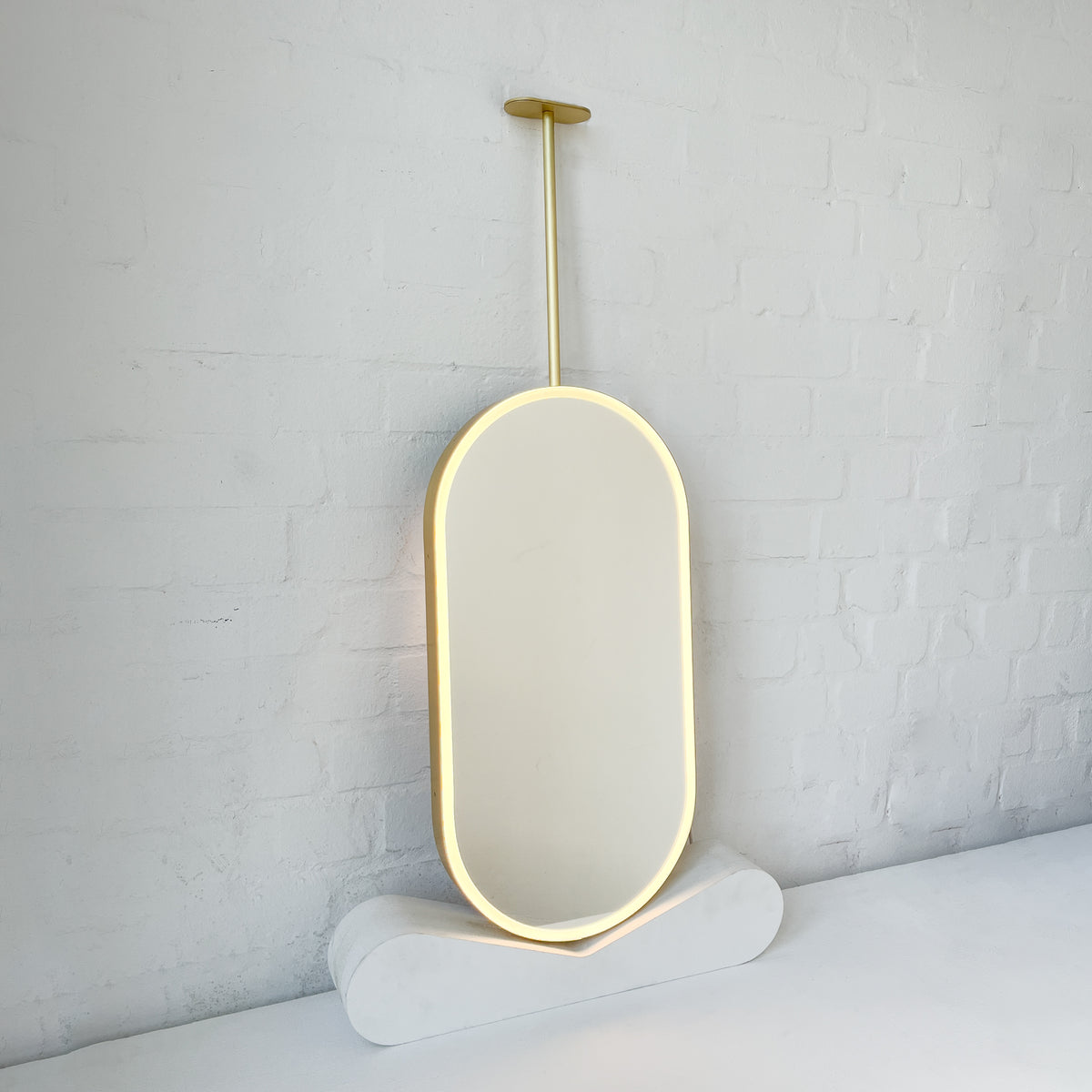 Capsula™ Ceiling Suspended Contemporary Mirror with a Brass Frame and Front Illumination