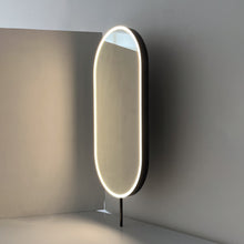 Modern front illuminated countertop pill shaped mirror with a blackened stainless steel frame