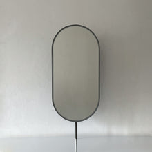 Modern countertop pill shaped mirror with a blackened stainless steel frame