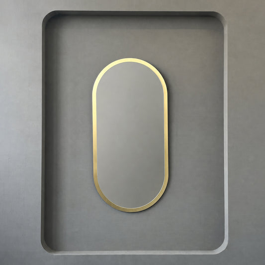 Modern Capsula™ pill shaped mirror with an architectural TIPO™ frame with brushed brass finish