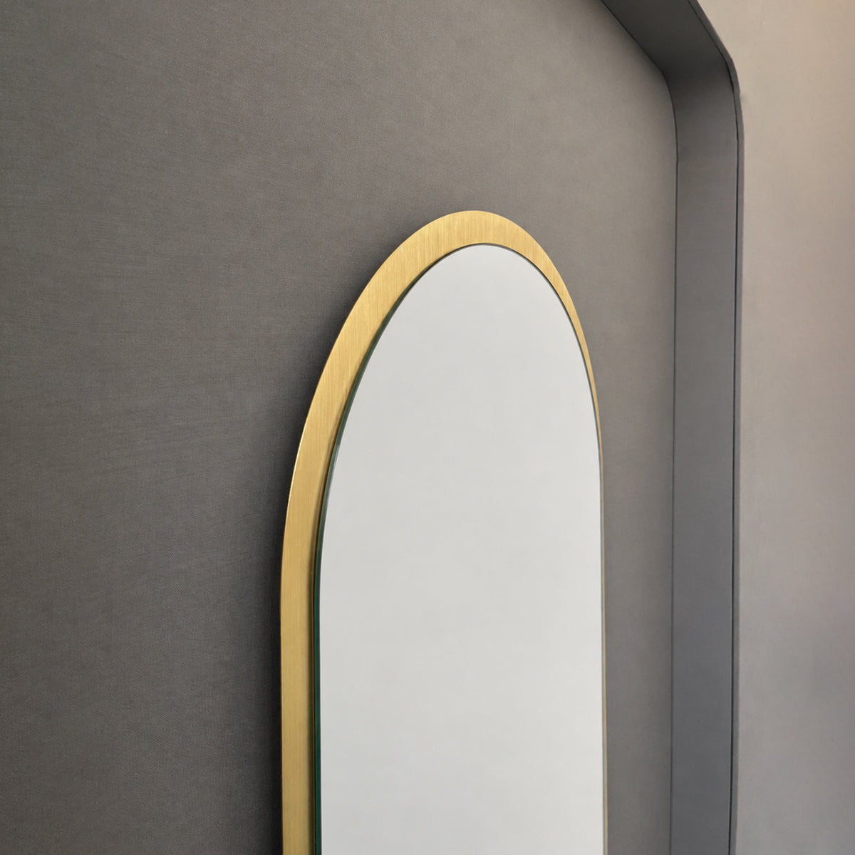 Modern Capsula™ pill shaped mirror with an architectural TIPO™ frame with brushed brass finish