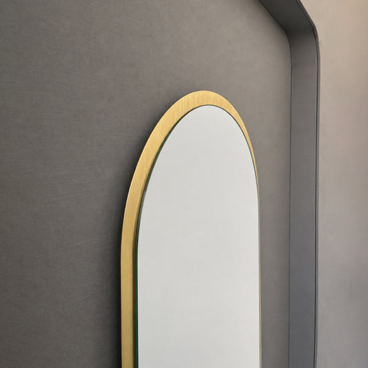 Modern Capsula™ pill shaped mirror with an architectural TIPO™ frame with brushed brass finish