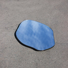 Modern freeform organic shaped mirror with a minimalist brass frame with a bronze patina finish