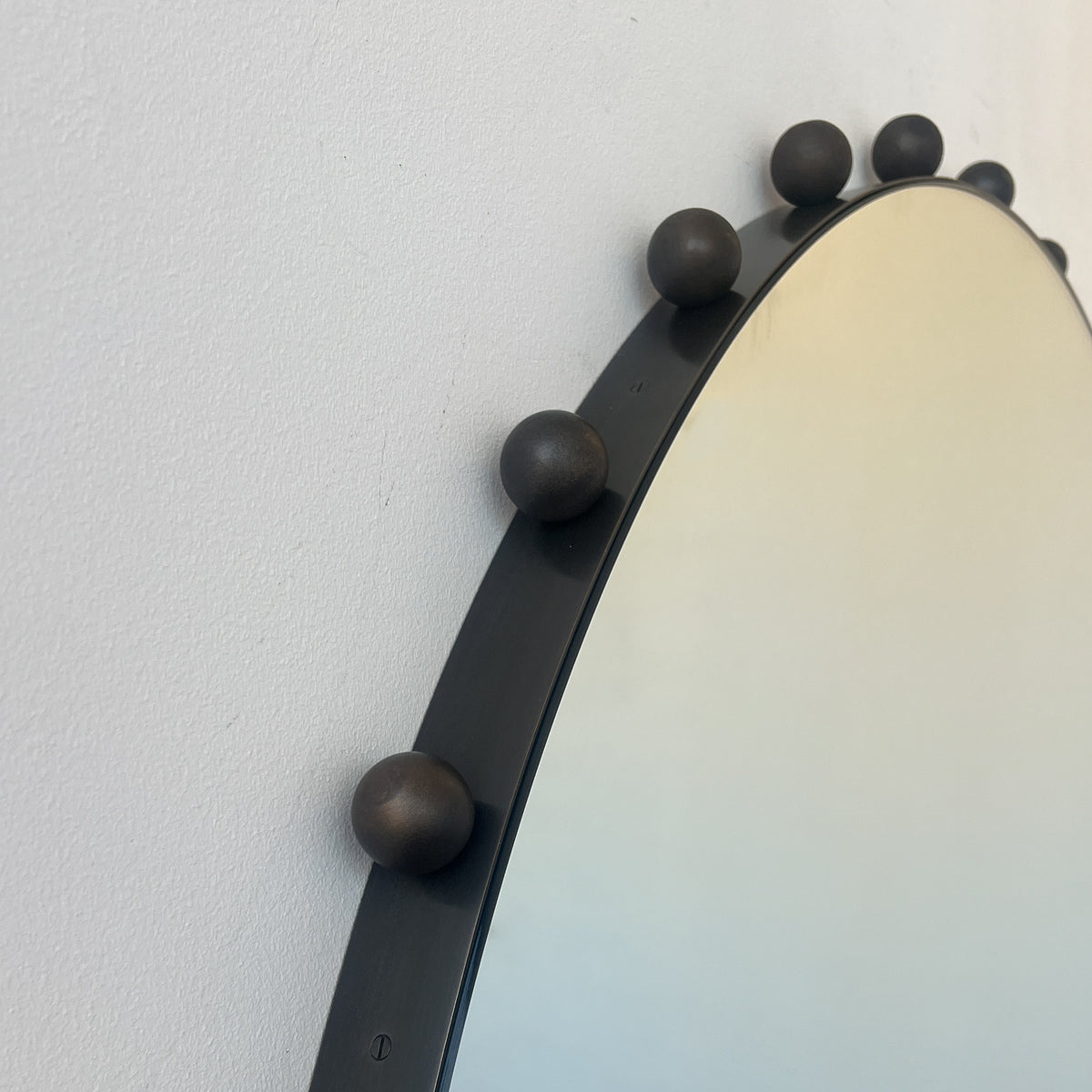 Alguacil & Perkoff Special Edition round mirror with decorative bobbins and a handcrafted blackened metal minimalist frame