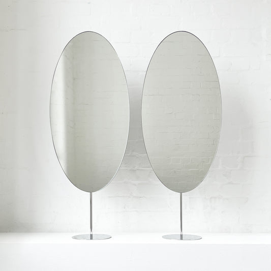 Countertop attached oval mirrors with a modern stainless steel frame