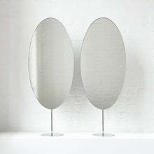 Countertop attached oval mirrors with a modern stainless steel frame