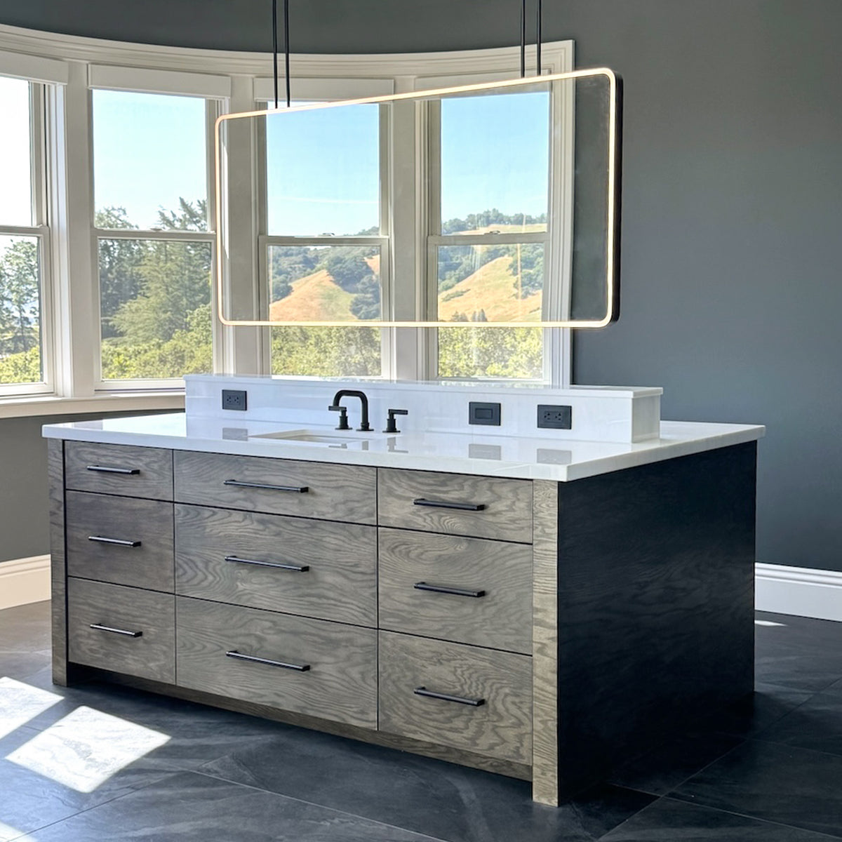 Oversized modern ceiling suspended Quadris™ front illuminated rectangular double sided mirror with a handcrafted blackened metal frame