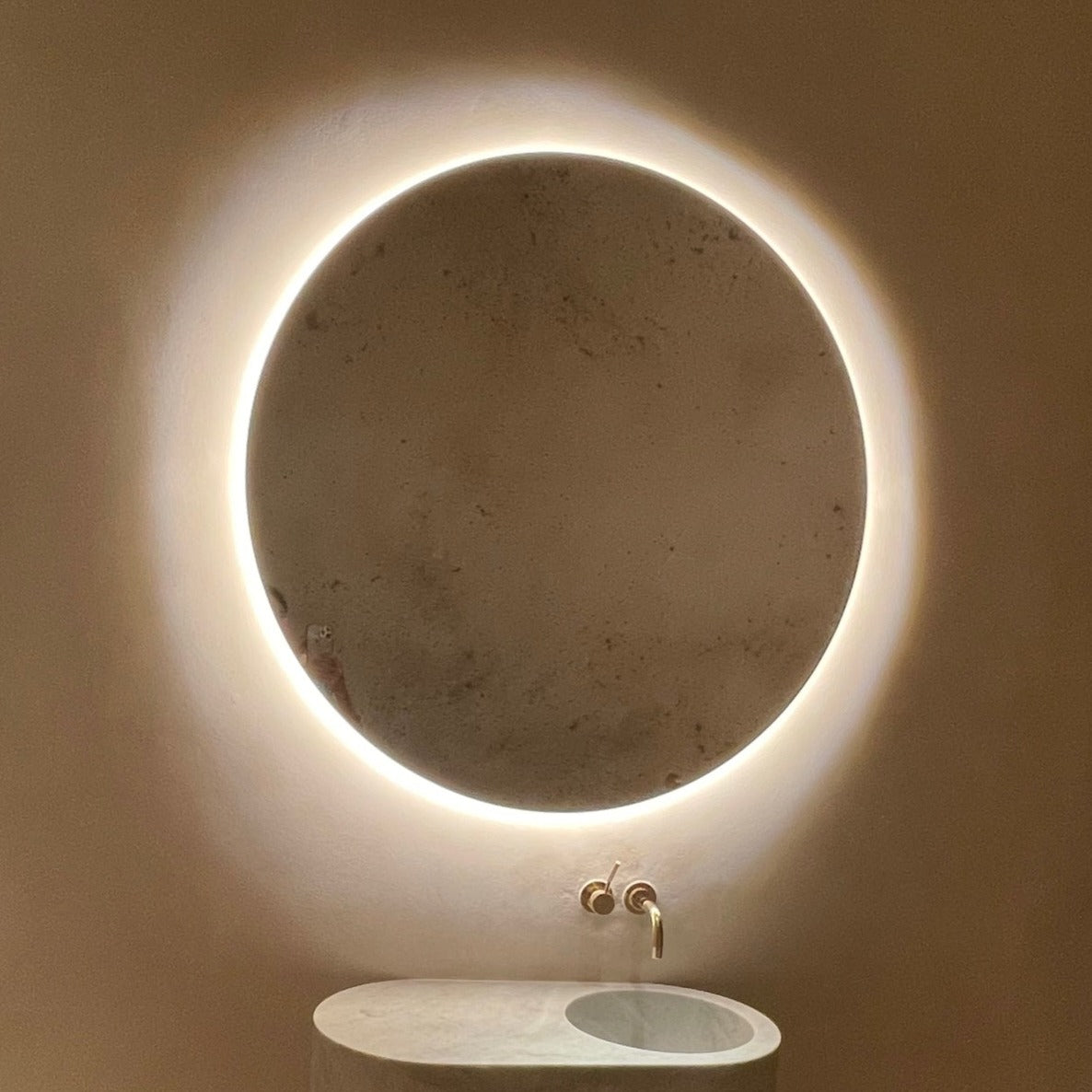 Orbis™ back Illuminated round mirror with an elegant bronze patina brass frame