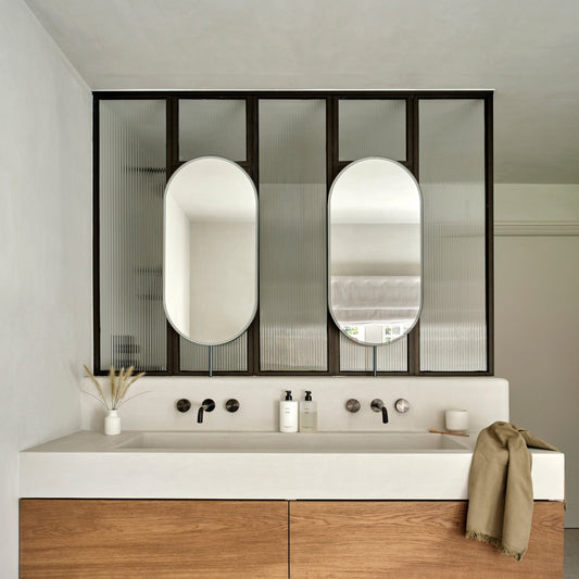 Set of two modern front illuminated Capsula™ countertop pill shaped mirrors with a minimalist blackened stainless steel frame