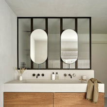 Set of two modern front illuminated Capsula™ countertop pill shaped mirrors with a minimalist blackened stainless steel frame