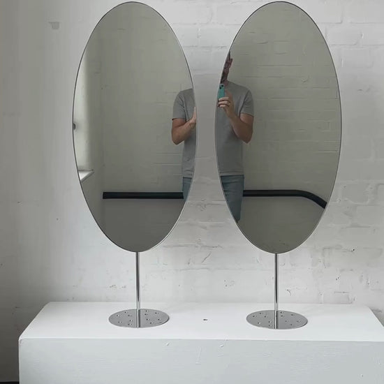Countertop attached oval mirrors with a modern stainless steel frame