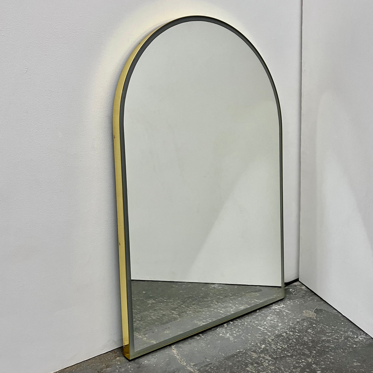 Contemporary front illuminated arch shaped Arcus™ mirror with a solid brass frame
