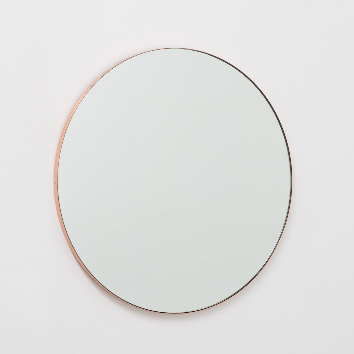 Modern round mirror with a minimalist copper frame