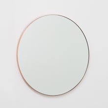 Modern round mirror with a minimalist copper frame